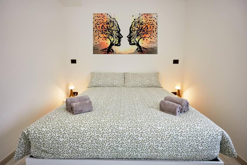een slaapkamer met een bed met twee schilderijen aan de muur bij Appartamento Moderno per 6 Aviano A/C Parking in Aviano