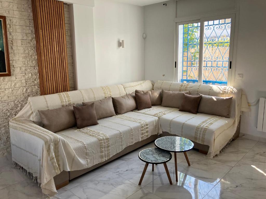 a living room with a couch and a table at Charmant duplex proche de la plage in Hammamet Sud