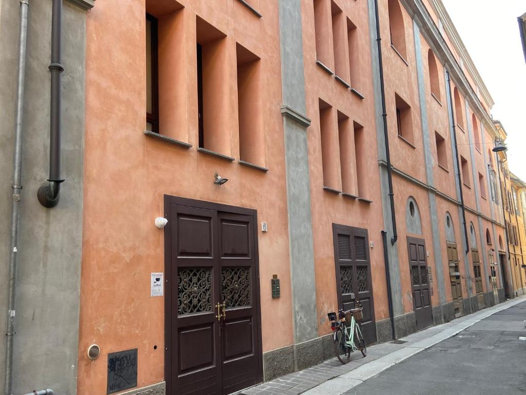 un bâtiment avec une porte et un vélo garé dans une rue dans l'établissement City Center - 50 metri dal Centro Storico, à Crémone