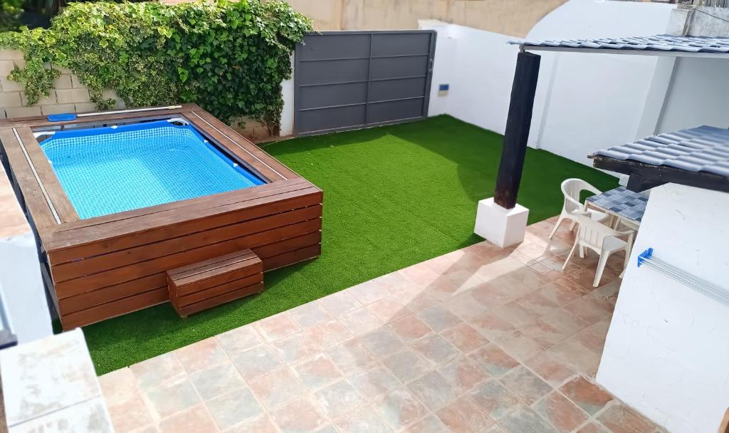 a small backyard with a swimming pool and grass at Chalet Bosque10 Piscina Privada entre la playa in Málaga