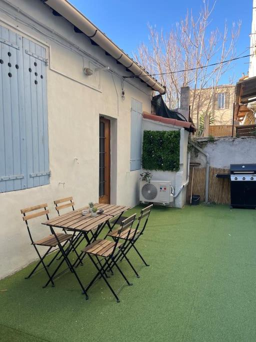 un patio avec une table et des chaises sur l'herbe dans l'établissement Studio avec extérieur, à Marseille