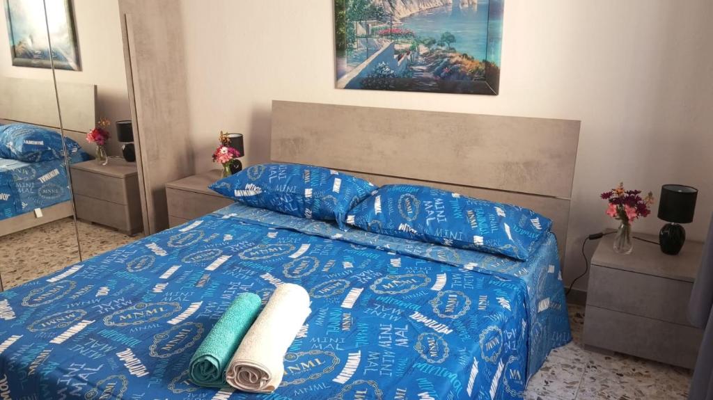 1 dormitorio con 1 cama con sábanas y almohadas azules en Flat in Olbia Centro, en Olbia