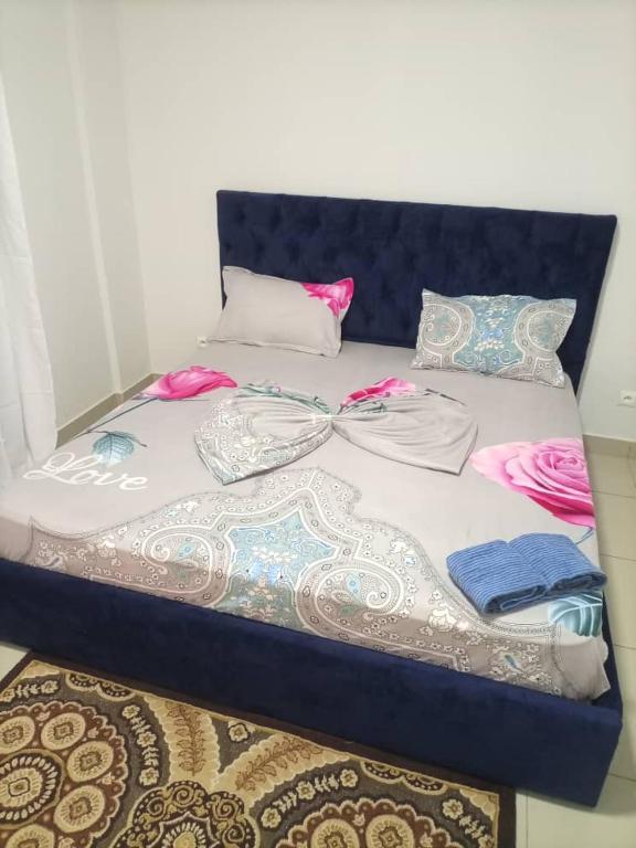 a bed with many pillows on top of it at Appartement MBAYE in Pointe-Noire