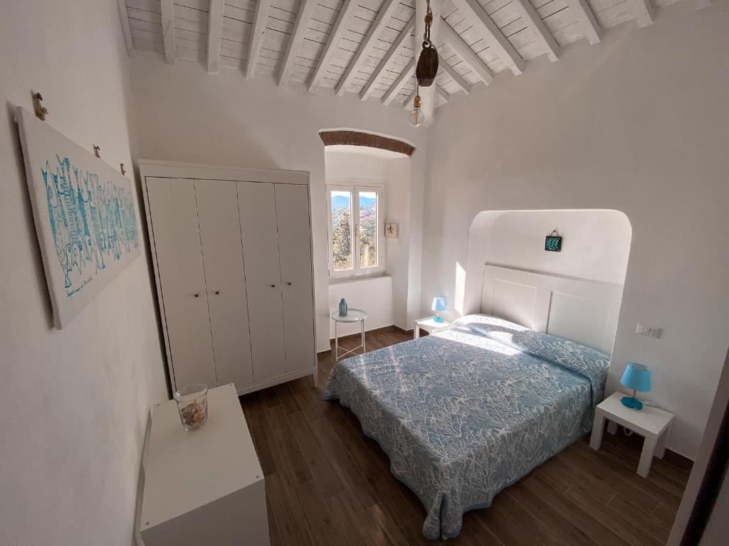 a white bedroom with a bed and a window at Casa Angè - Lerici, Golfo dei Poeti in Lerici