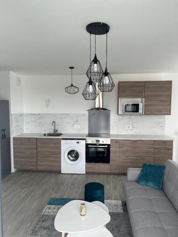 un salon avec un canapé et une cuisine dans l'établissement Superbe 3 pièces avec balcon pour 5 personnes, à Villiers-le-Bel