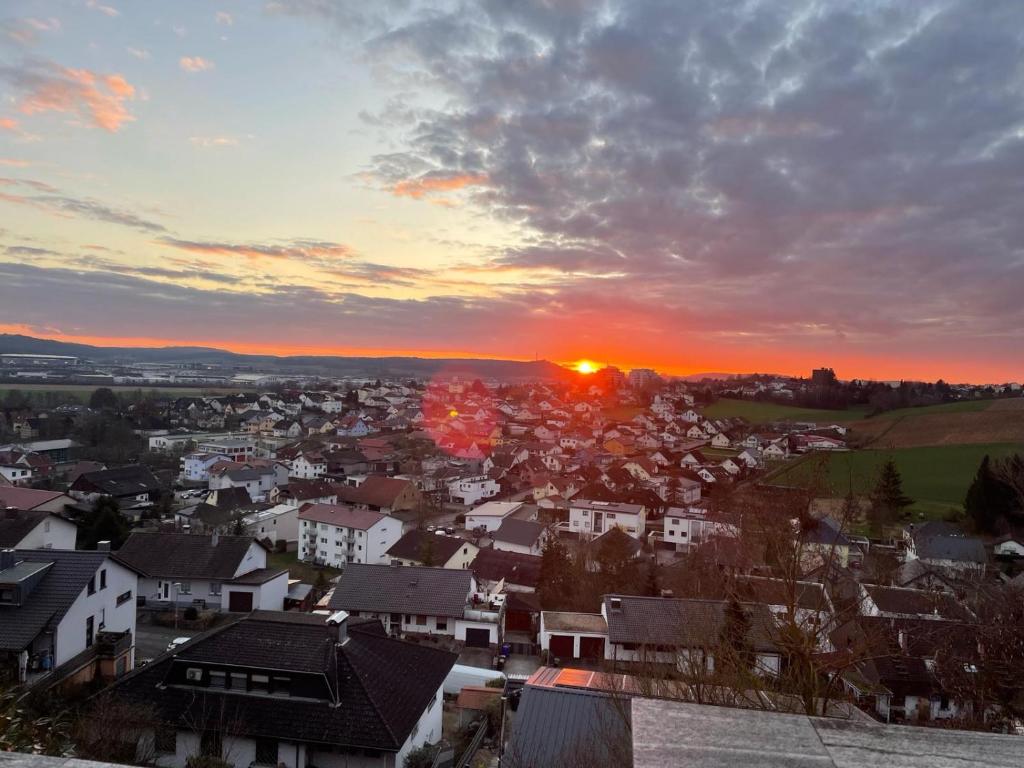 a view of a town with the sunset in the background at Ferienwohnung Panoramablick in Sinsheim