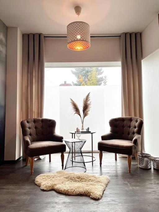 a living room with two chairs and a large window at Zentrale Stadtwohnung, Bahnhofsnähe, OG-Krankenhaus, OG-Messe, EuropaPark in Offenburg