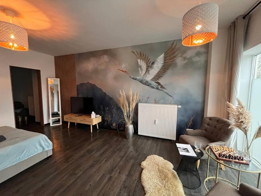 a bedroom with a large painting of birds on the wall at Zentrale Stadtwohnung, Bahnhofsnähe, OG-Krankenhaus, OG-Messe, EuropaPark in Offenburg