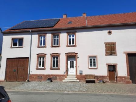 duży biały dom z czerwonym dachem w obiekcie Bauernhaus Schunck im Bliesgau w mieście Blieskastel