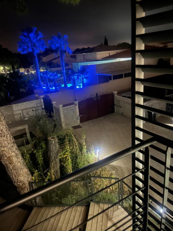 - une vue sur un bâtiment la nuit avec des lumières bleues dans l'établissement Mimosas résidence, à Juvignac
