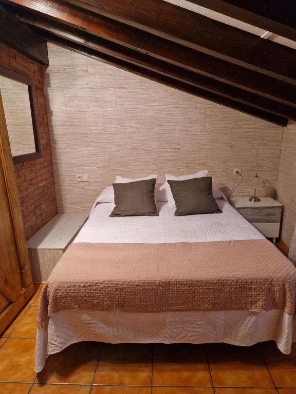 Un dormitorio con una gran cama blanca con dos almohadas. en Adrimar, en Quijas