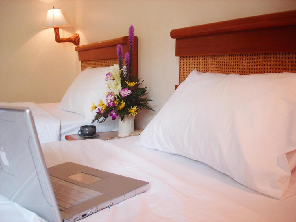 un ordenador portátil sobre una cama con flores en Sunset Mansion, en Patong Beach