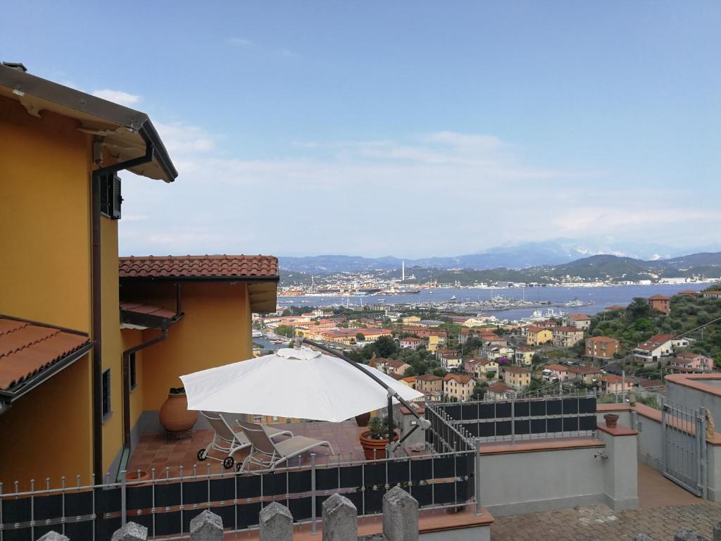 balcón con mesa y sombrilla blanca en I POGGI SUL GOLFO, en La Spezia