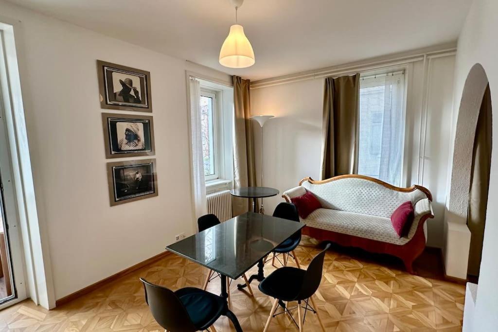 ein Wohnzimmer mit einem Sofa, einem Tisch und Stühlen in der Unterkunft Wunderschöne Gartenwohnung in Zürich in Zürich