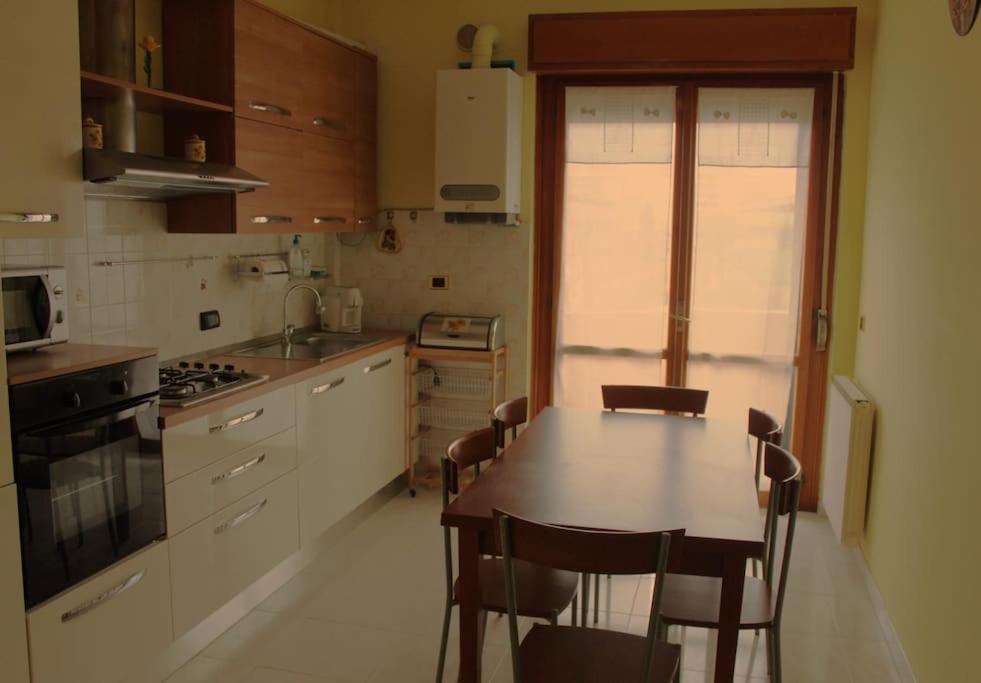 une cuisine avec une table et des chaises. dans l'établissement Casa Girasole, à Montesilvano