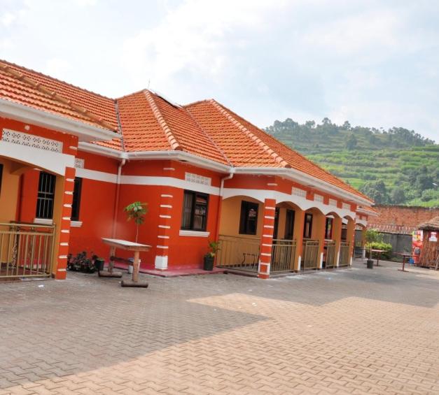 a red building with a table in front of it at Kisoro Homely Suites in Kisoro