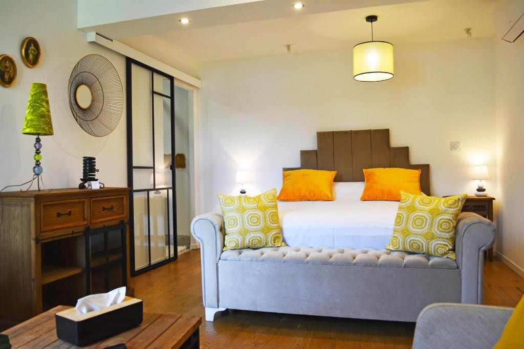 sypialnia z łóżkiem z żółtymi i pomarańczowymi poduszkami w obiekcie Manoir Drissia - Tours Centre, France w mieście Saint-Avertin