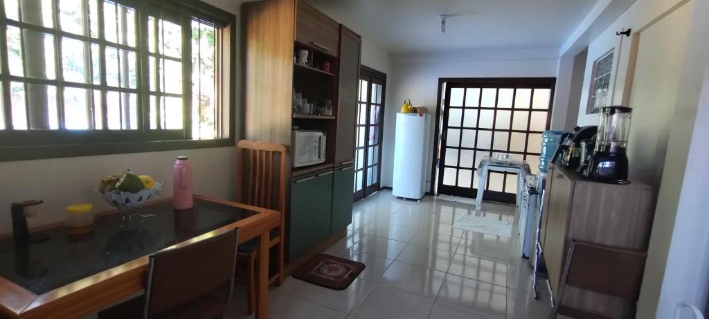 een keuken met een tafel en een koelkast in een kamer bij Hostel de Gaia in Santa Cruz do Sul