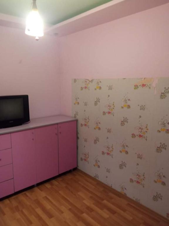 een kamer met een paarse kast en een tv aan de muur bij Апартаменты in Rustavi
