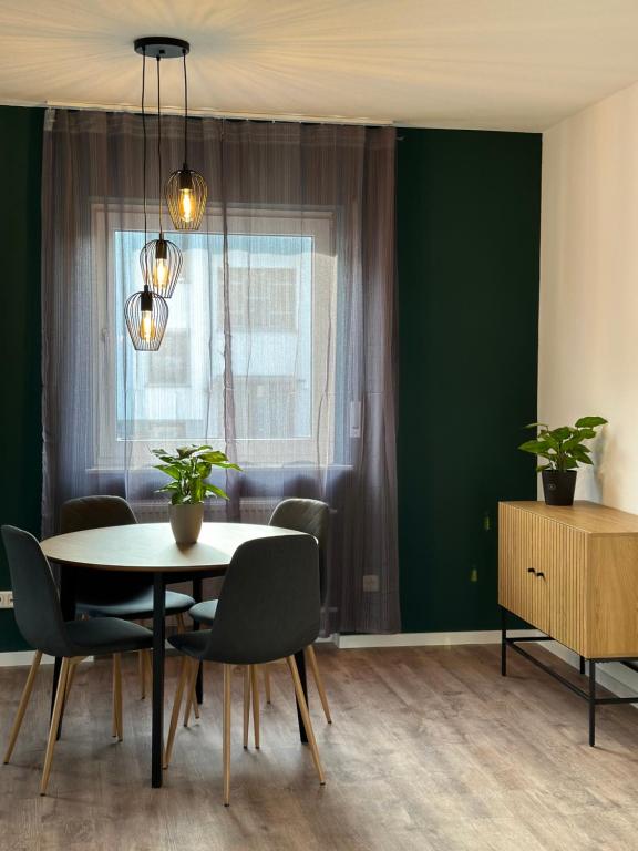 uma sala de jantar com paredes verdes e uma mesa e cadeiras em Hauptstadt Mitte em Waigolshausen