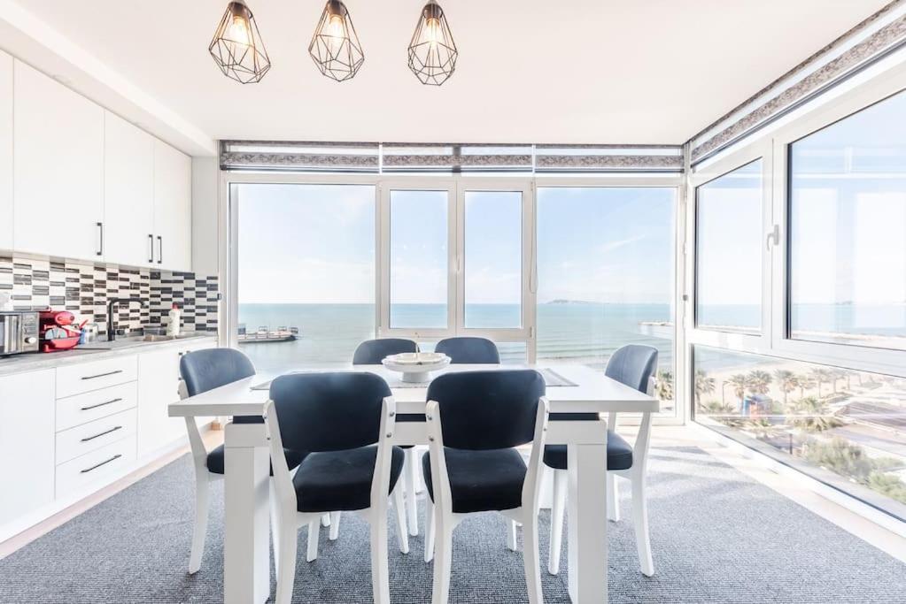 a white dining room with a table and chairs at Seaview Luxury Suite by PS in Golem