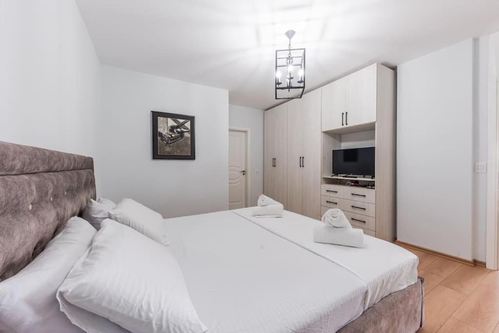a white bedroom with a large bed and a television at Seaview Luxury Suite by PS in Golem