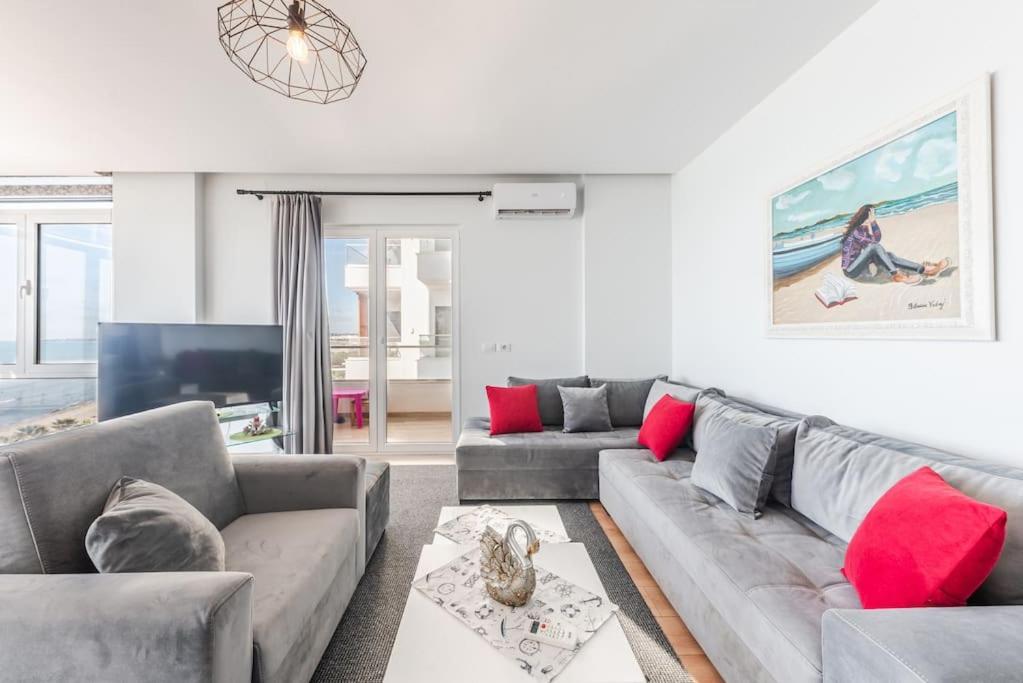 a living room with a gray couch and red pillows at Seaview Luxury Suite by PS in Golem