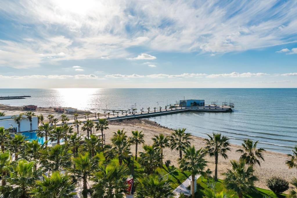 a dock in the ocean with palm trees on the beach at Seaview Luxury Suite by PS in Golem