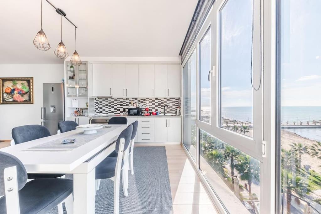 a kitchen and dining room with a white table and chairs at Seaview Luxury Suite by PS in Golem