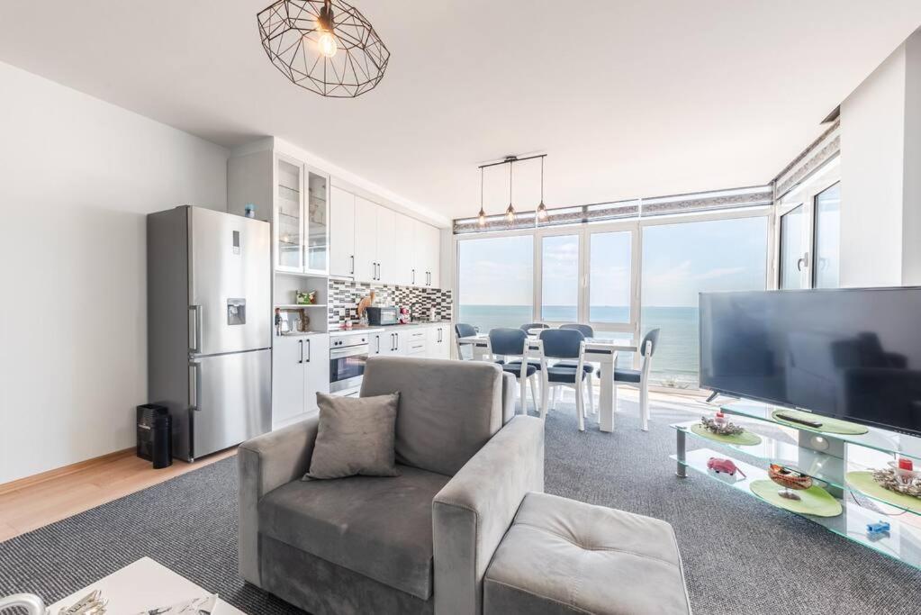 a living room with a couch and a large screen tv at Seaview Luxury Suite by PS in Golem