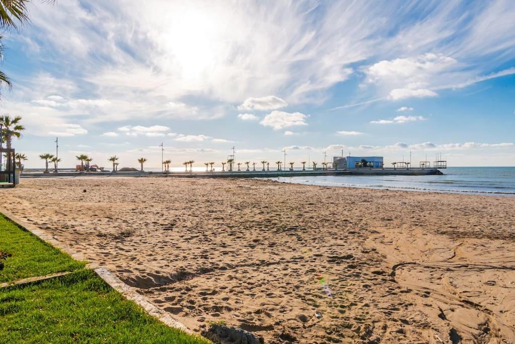 a sandy beach with palm trees and the ocean at Seaview Luxury Suite by PS in Golem