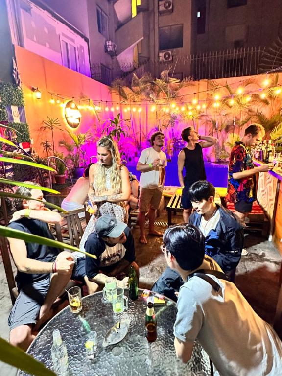 um grupo de pessoas sentadas em torno de uma mesa em um bar em Llaqta Wasi em Lima