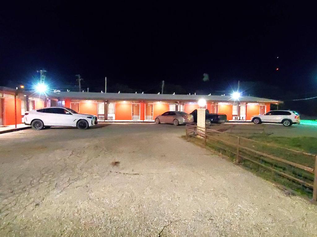 un edificio con coches aparcados delante de él por la noche en Holiday Host Motel & RV Park, en Sonora