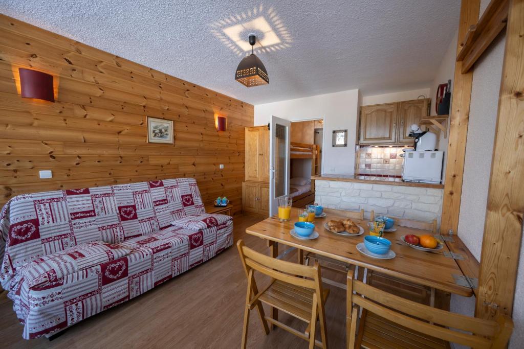 a living room with a couch and a table at Doux Crépuscule - Au bord des pistes - Parking in Enchastrayes
