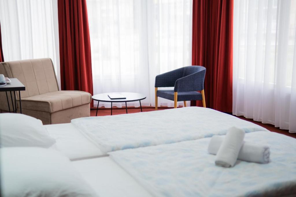 a hotel room with a bed and a chair at Soba Kašmir in Bugojno