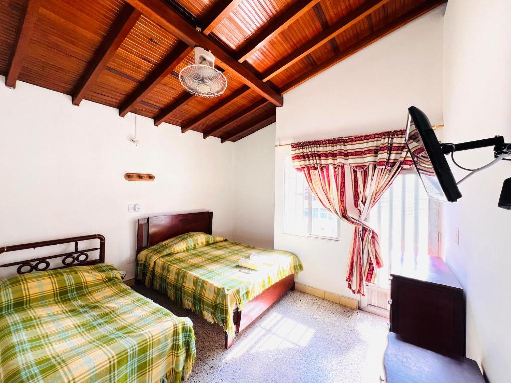 um quarto com 2 camas e uma janela em Hospedaje La Nave em Bello