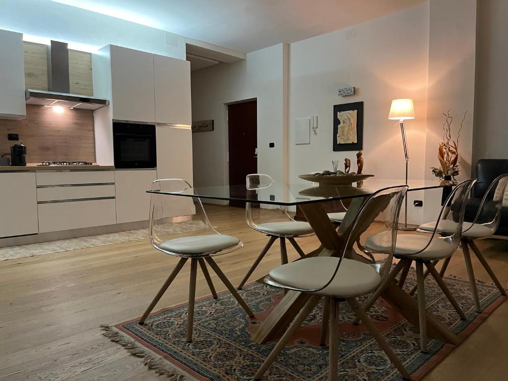 una sala da pranzo con tavolo in vetro e sedie di Interno 12 Sweet Home a Verona