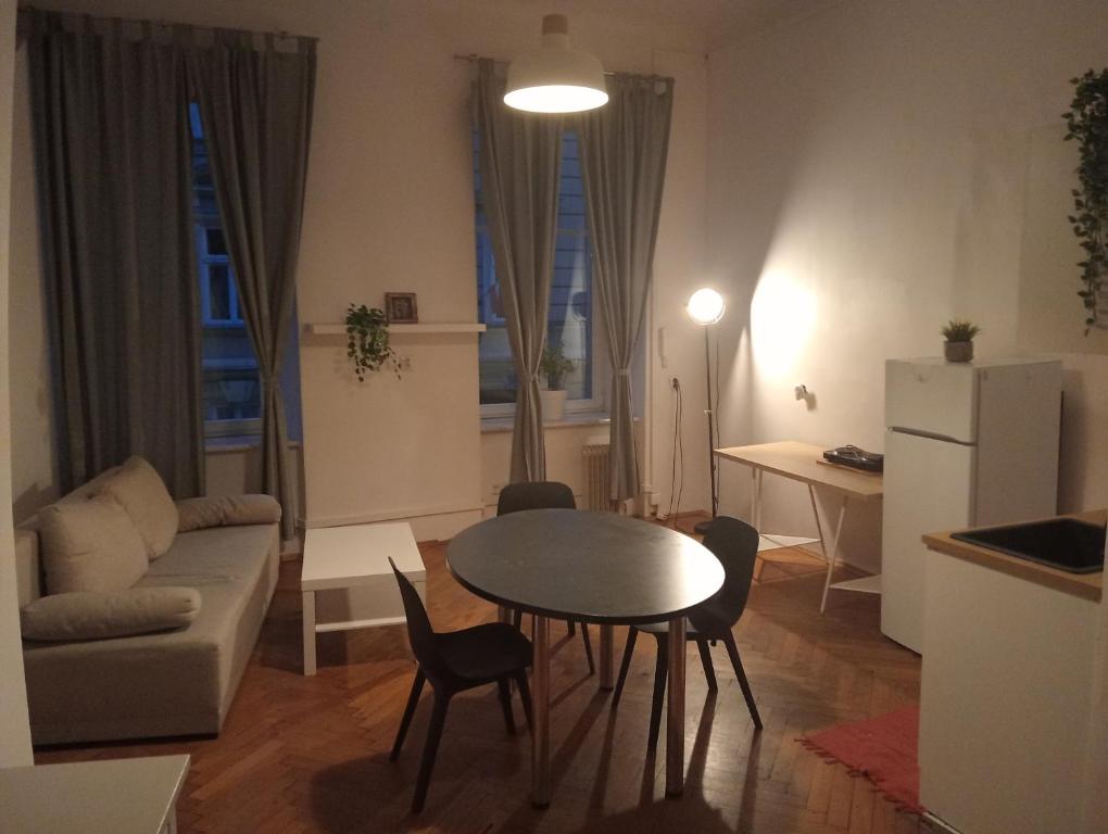 uma cozinha e sala de estar com mesa e cadeiras em Apartament Batorego em Cracóvia
