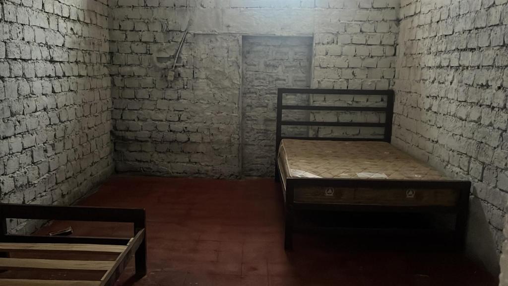 a room with two beds in a brick wall at No más atención in Miraflores