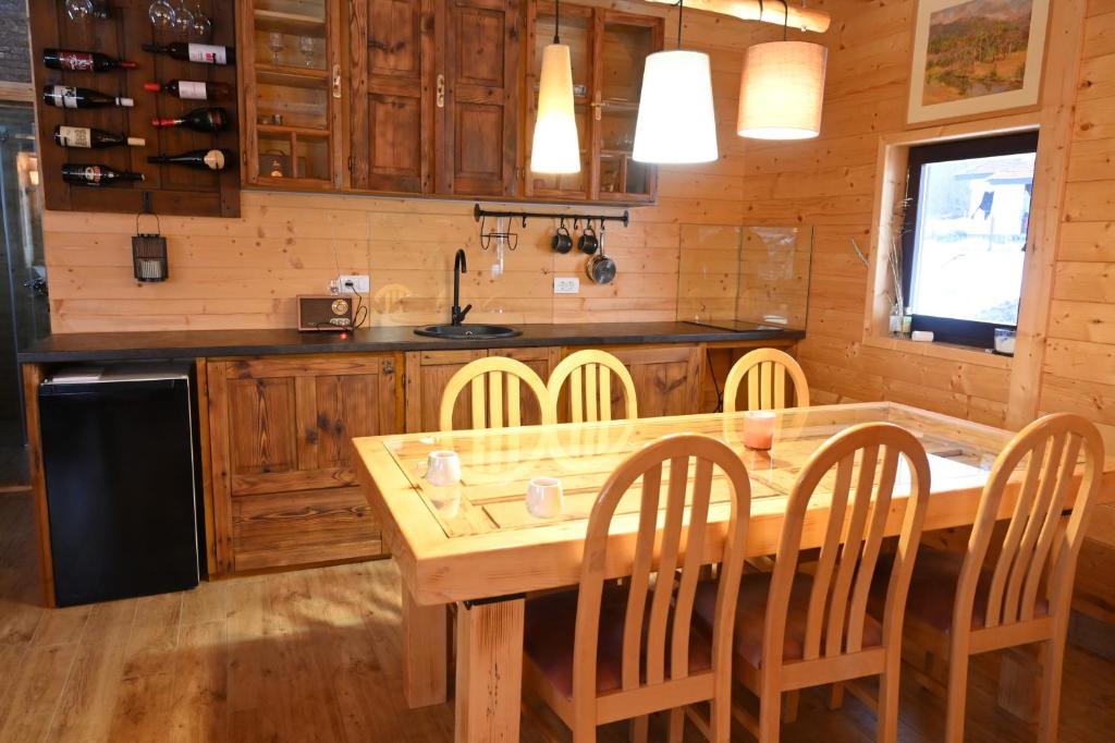 une cuisine avec une grande table et des chaises en bois dans l'établissement Skroviste, Zlatibor-Vodice, à Zlatibor