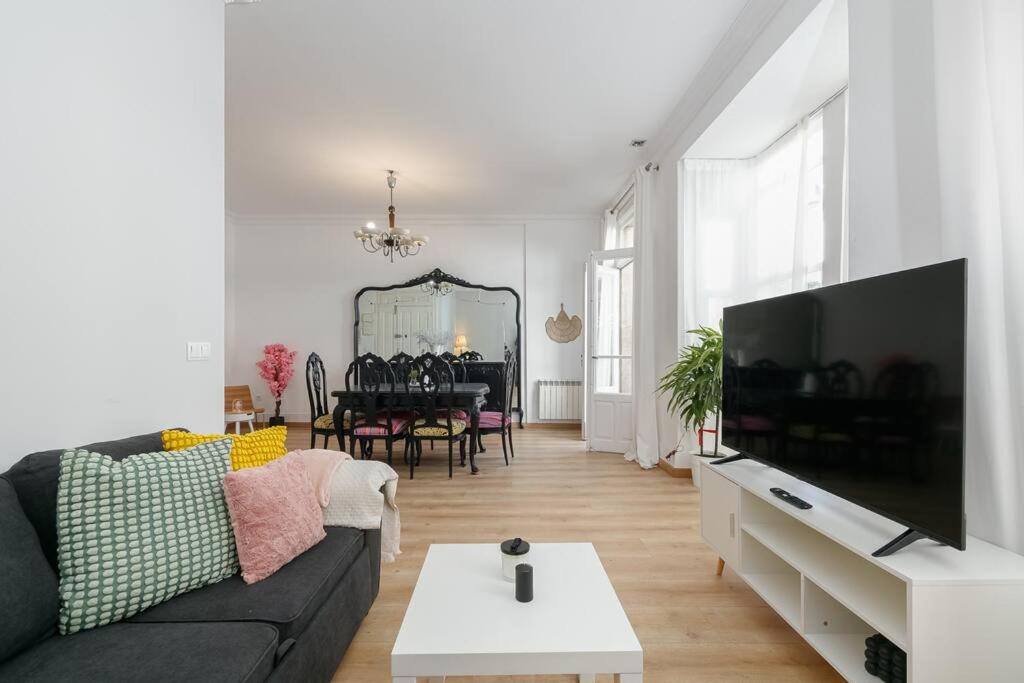 ein Wohnzimmer mit einem schwarzen Sofa und einem Tisch in der Unterkunft Estilo, luz y elegancia en Vigo by CABANA Rentals in Vigo