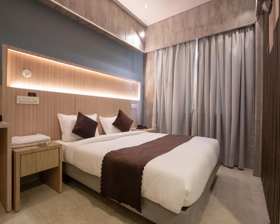 a bedroom with a large bed in a room at Hotel Grand Seasons- Navi Mumbai in Navi Mumbai