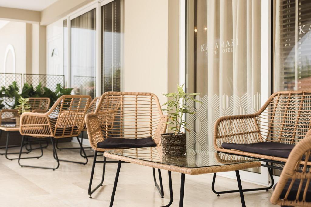 a group of wicker chairs and tables on a balcony at Kalamaki Beach Hotel, Zakynthos Island in Kalamaki