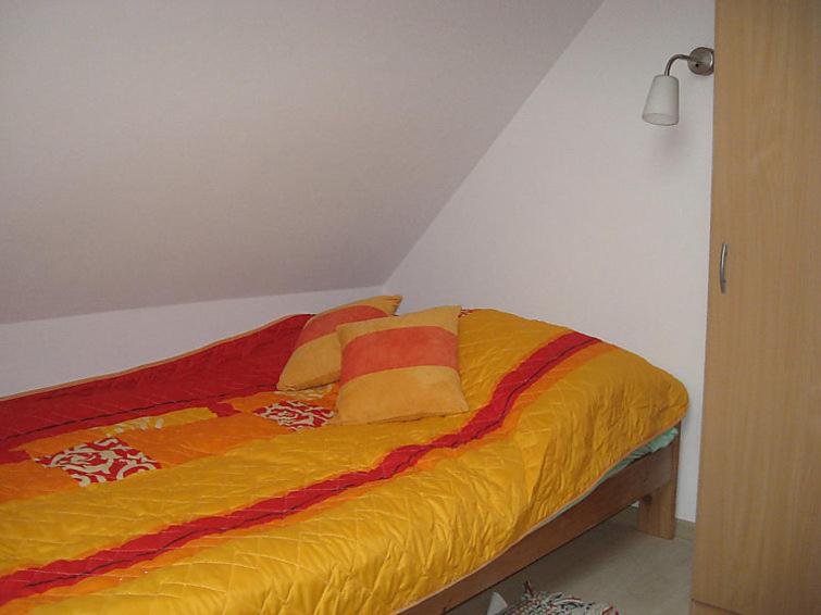 a bedroom with a bed with yellow and red sheets at Wynajem willi z 3 sypialniami Sasino, in Sasino