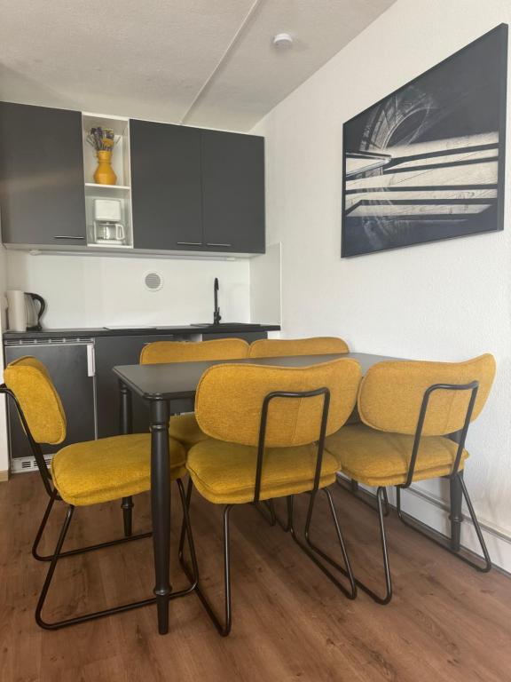 ein Esszimmer mit einem Tisch und gelben Stühlen in der Unterkunft Stressless aktivCARD Bayerischer Wald inklusive in Sankt Englmar