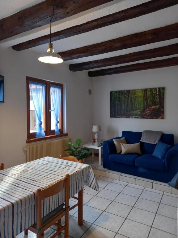 sala de estar con sofá azul y mesa en Appartamento 'Io e te', en Pieve dʼAlpago