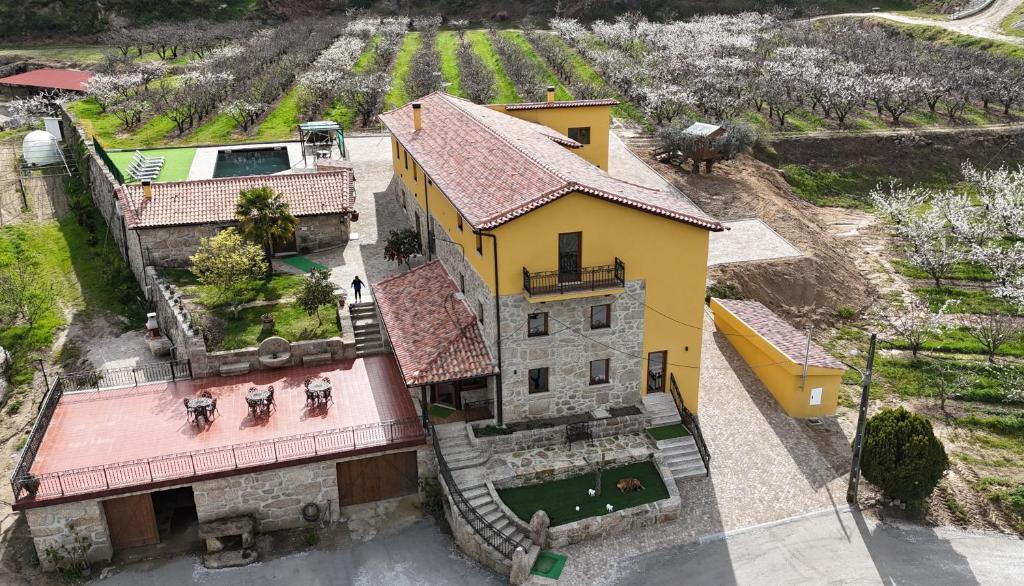 an aerial view of a yellow house with a yard at Quinta do Limite - Agroturismo in Covilhã