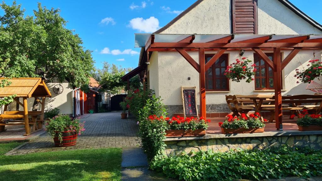 a building with flowers in a yard with a patio at Old House Bogacs in Bogács