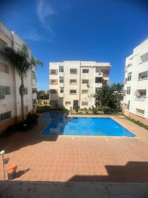 une piscine devant deux grands immeubles dans l'établissement Appartement in Mohammedia, à Mohammedia