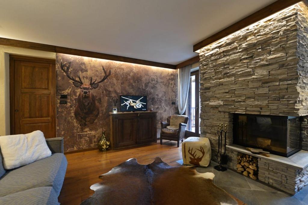 sala de estar con chimenea de piedra y TV en L'Ame du Mont blanc vda.cir 0061, en Pré-Saint-Didier